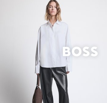 Witte button-up shirt met een klassieke kraag, gecombineerd met donker gestreepte broek. Model houdt een bruine handtas vast, tegen een neutrale achtergrond.