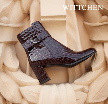 Ciemnobrązowe botki sięgające kostki wykonane z błyszczącej wytłaczanej skóry. Posiadają detal w postaci klamry, kwadratowy obcas oraz zakończenie w szpic.