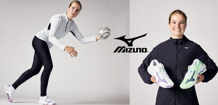 Zapatillas deportivas Mizuno con un diseño en blanco y verde claro, suela texturada, logo prominente, combinadas con una chaqueta negra con cremallera y leggings.