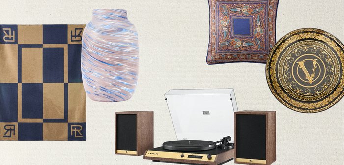 Deux coussins à motifs, un vase en verre, une écharpe à carreaux et une platine vinyle vintage avec des haut-parleurs en bois sur un fond clair.