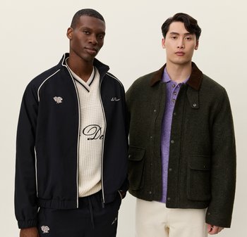 Giacca nera con zip e accenti bianchi, maglione di colore crema con texture e logo, e giacca di lana verde scuro con colletto e tasche marroni.