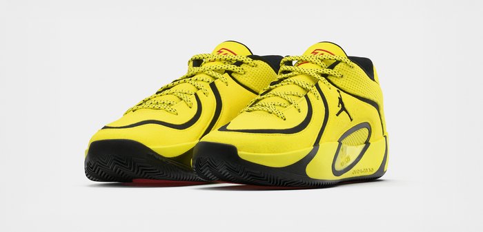Φωτεινά κίτρινα και μαύρα αθλητικά παπούτσια με κορδόνια, υφασμένα πέλματα και λογότυπο Jordan στο πλάι, εμφανιζόμενα από μπροστινή γωνία.
