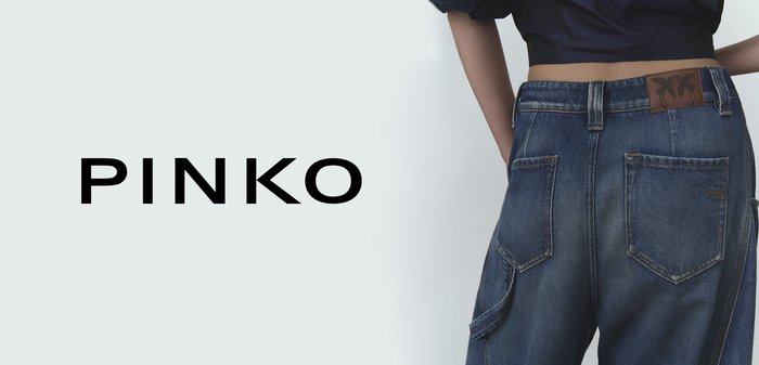 Denim jeans with a high waist, two back pockets, and a brown leather patch featuring a logo. Dark blue fabric with a textured finish.