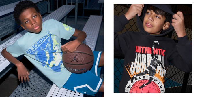 Chłopiec poprawiający czarną bluzę z kapturem z grafiką koszykarza i napisem "AUTHENTIC JORDAN", stojący obok ogrodzenia z siatki.
