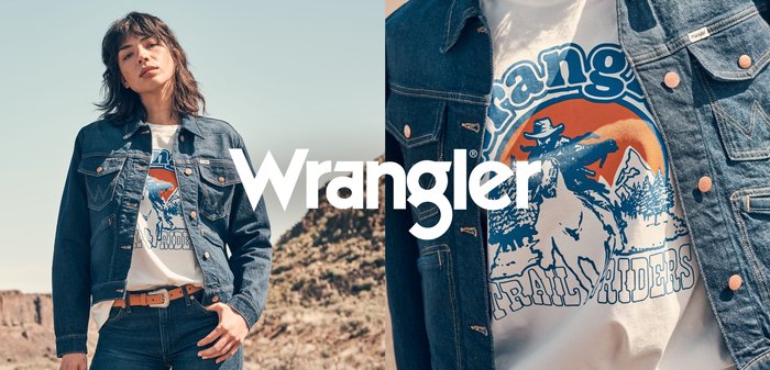 Jeansjacka med distinkt sömnad och kopparknappar, bärs över en vit T-shirt med en färgglad grafik av en cowboy och berg.