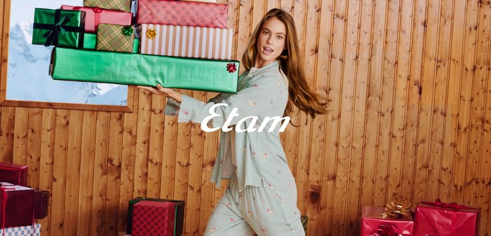 Komplet piżam w jasnej zieleni w paski, z kolorowymi motywami. Model niesie kilka zapakowanych prezentów w różnych kolorach i wzorach.