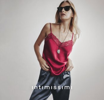 Camisole in raso rosso con pizzo, abbinato a pantaloni in raso blu. Indossato con occhiali da sole neri e una semplice collana con pendente.