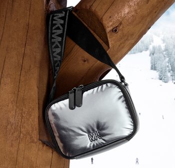 Glänsande silverfärgad axelväska med dragkedja och svart texturerad rem. Har präglad logotyp och slät, vadderad yta.