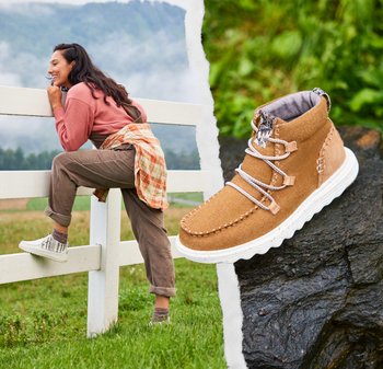 Stivale alla caviglia in tessuto marrone con suola bianca e cuciture a contrasto, caratterizzato da lacci incrociati e una fodera interna a motivo.
