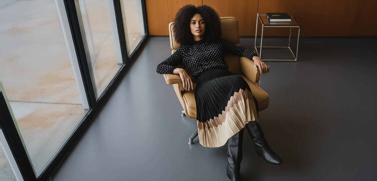 Musta-valkoinen pallokuvioinen toppi yhdistettynä laskostettuun, väriblokkihameeseen, jossa mustaa, beigeä ja kermaa. Yhdistetty polven korkeiden mustien saappaiden kanssa.