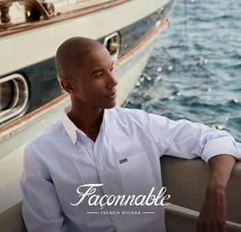 Chemise à rayures bleues claires et blanches à boutons, avec un col blanc, portée par une personne sur un bateau, devant un fond d'eau et de yacht.