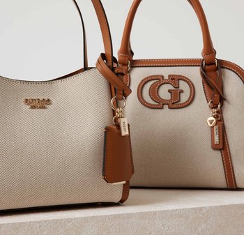Due borse a tracolla realizzate in tessuto beige testurizzato con manici e dettagli in pelle marrone. Una presenta un logo e un portachiavi; l'altra ha un'etichetta.