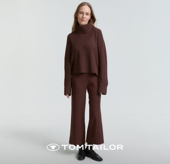 Brązowy krótki golf z prążkowaną fakturą, zestawiony z dopasowanymi, rozszerzanymi spodniami. Obuwie czarne. Prosty, nowoczesny design.