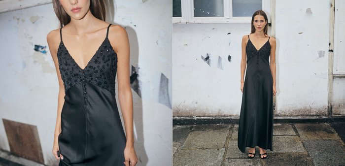 Zwarte satijnen maxi-jurk met een V-hals, versierde lijfje, dunne bandjes en een soepel, vloeiend silhouet. Voorzien van decoratieve knopen.