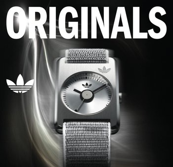 Eckige Armbanduhr aus Edelstahl mit silbernem Zifferblatt, schwarzen Stunden- und Minutenzeigern sowie grauem Textilarmband. Verfügt über das Adidas-Logo bei 12 Uhr.