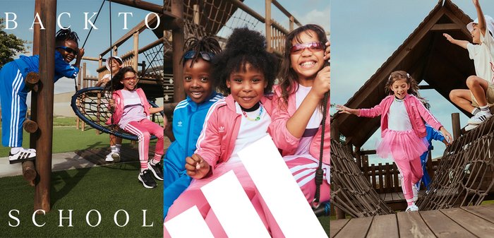 Quatro crianças brincam num parque infantil de madeira. Elas vestem fato de treino desportivo colorido em azul e rosa, com logótipos e texturas visíveis.
