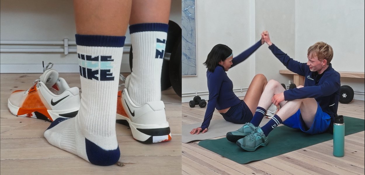 Vita och orangea sportskor med svart sula och grå snören; knähöga strumpor med blå och vit text. Två personer tränar på mattor.