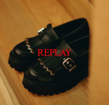Scarpe in pelle nera con suola spessa, caratterizzate da un design frangiato, hardware decorativo e un accentuato con una fibbia argentata.