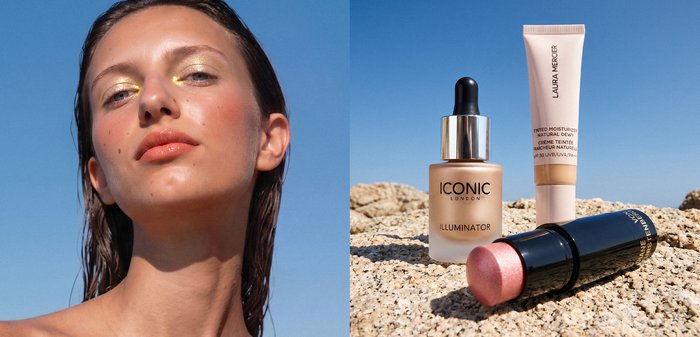 Jeune femme avec maquillage lumineux à côté de fond de teint, illuminateur, crème hydratante teintée et enlumineur éclatant sur une surface rocheuse sous un ciel clair.