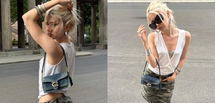 Blonde Frau trägt ein weißes ärmelloses Oberteil, Camouflage-Rock, schwarze offene Schuhe, große Sonnenbrille und hält eine Jeans-Handtasche auf der Straße in der Stadt.
