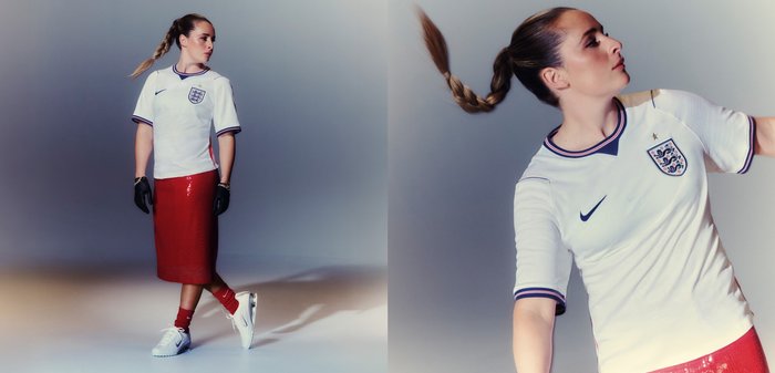 Femme avec une queue de cheval tressée, portant un maillot de football anglais, une jupe midi rouge, des gants noirs, des chaussettes rouges et des baskets blanches, posant à l'intérieur.