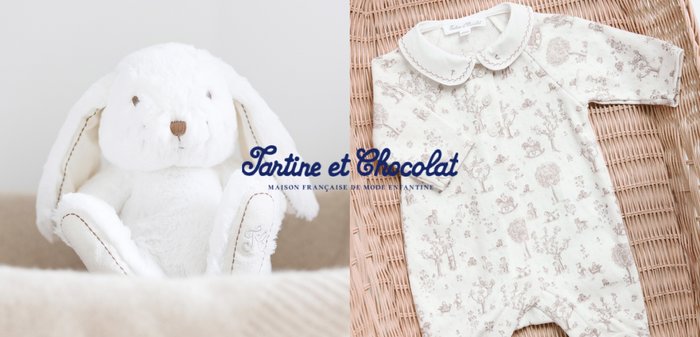 Bijela plišana igračka zečić pored bež bodija za bebe s uzorkom i ovratnikom, postavljen na pletenu površinu, marka Tartine et Chocolat.