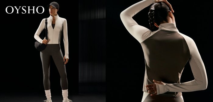 Frau mit geflochtenem Haar, die ein langärmliges, figurbetontes zweifarbiges Sportoberteil trägt und mit einem Arm über dem Kopf und dem anderen hinter dem Rücken posiert.