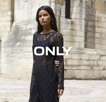 Zwarte kantjurk met lange mouwen en een ronde halslijn, gekenmerkt door een doorzichtige textuur en gelaagd ontwerp, tegen een stenen achtergrond.