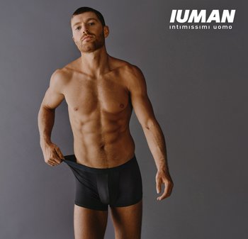 Slip boxer da uomo neri con design aderente, tessuto liscio e una fascia in vita larga. Modello a mezza posa su sfondo grigio.