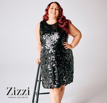 Svart paljettklänning med cirkulära reflekterande detaljer, ärmlös design, rund halsringning, bärs av en modell som lutar sig mot en stol, märke Zizzi.