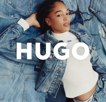Jeansjacke mit einem hellblauen Waschungslook, klassischer Schnitt und einem weißen Rollkragenoberteil darunter. Blaue Logo-Akzente sichtbar.
