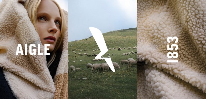 Plaid en polaire beige chaud avec une texture douce. L'arrière-plan présente des collines herbeuses et des moutons, avec un texte en gras "AIGLE" et "1853" en superposition.