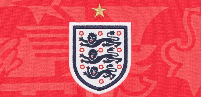 Blason de l'équipe de football d'Angleterre avec trois lions noirs et des roses rouges sous une seule étoile d'or sur un fond abstrait rouge.
