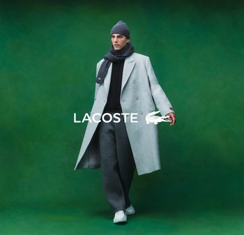 Abrigo de lana gris con diseño de doble botonadura, suéter negro y pantalones grises. El modelo lleva un gorro gris y una bufanda, complementados con zapatillas blancas.