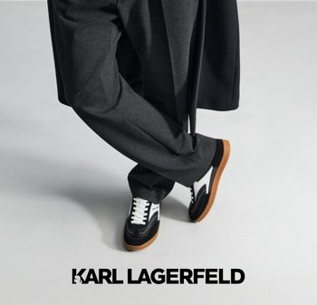 Zapatillas en blanco y negro con suela de goma, estilo con cordones y detalles en contraste, combinadas con pantalones de traje en gris oscuro.