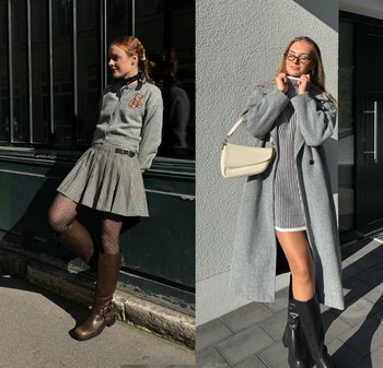 Două femei îmbrăcate în haine exterioare gri și cizme până la genunchi stau afară; una poartă o fustă plisată cu dresuri cu model, cealaltă o rochie în dungi și o geantă bej.