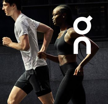 Deux coureurs en tenue de sport : un homme en t-shirt blanc à manches courtes et en shorts noirs, et une femme en brassière de sport noire et leggings.