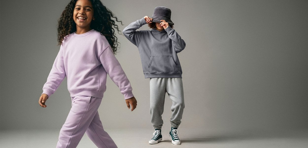 Purple sweatshirt and sweatpants, soft material, relaxed fit. Gray hoodie with pouch pocket, gray sweatpants, and green sneakers.