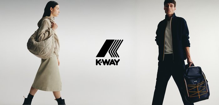 Borsa beige trapuntata tenuta da una donna in un vestito chiaro e un uomo in una giacca navy con zip e uno zaino nero con spallacci arancioni.