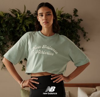T-shirt crop vert menthe en tissu doux avec "New Balance Athletics" en relief en écriture blanche ; assorti avec des leggings noirs.