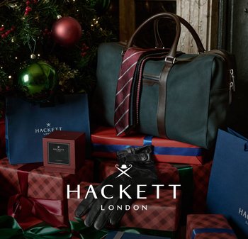 Green leather duffel bag with brown accents, red and navy striped ties, black gloves, and gift boxes in a festive setting.