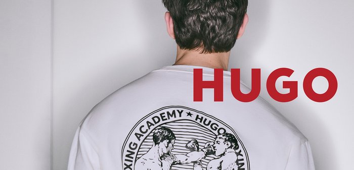 Weisses T-Shirt mit einem Boxgrafik auf dem Rücken, schwarzer Illustration und dem Text „Boxing Academy“ sowie „HUGO“. Glatte Textur.