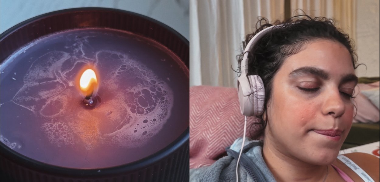 Fioletowa świeca w czarnym żebrowanym pojemniku, z migoczącym płomieniem. Obok osoba w różowych słuchawkach na uszach, z zamkniętymi oczami, zrelaksowana.