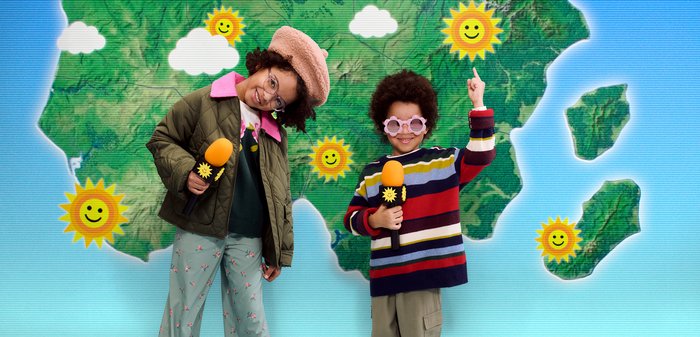 Deux enfants avec des microphones se tiennent devant une carte affichant des icônes de soleil sur différentes régions.