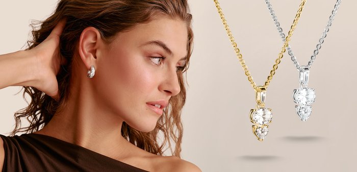 Woman with curly hair wearing silver earrings, looking to the side, with gold and silver diamond pendant necklaces displayed nearby.