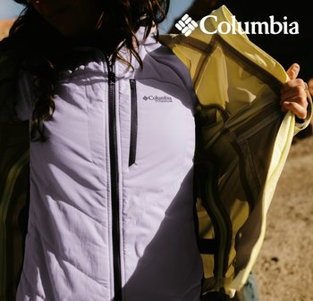 Veste légère Columbia en violet clair avec fermeture éclair noire, présentant un intérieur jaune et un logo sur la poitrine, mettant en valeur une texture matelassée.