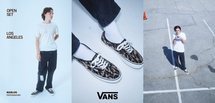 Scarpe Vans con upper in stampa leopardata, lacci bianchi e suole nere; abbinati a pantaloni neri a vestibilità ampia e a una t-shirt bianca sdrucita.