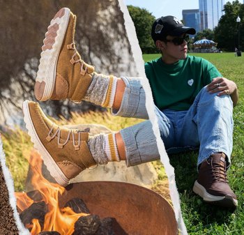 Stivaletti alla caviglia marroni con lacci, pannelli testurizzati e suole crema; abbinati a calzini grigi con strisce gialle, su erba vicino a un fuoco.