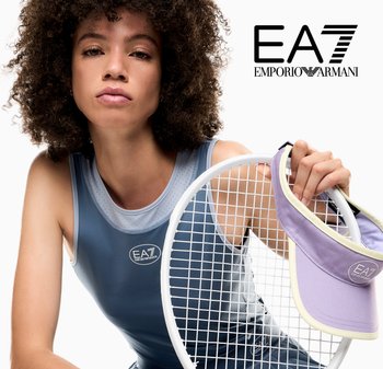 Mujer con ropa deportiva sosteniendo una raqueta de tenis y una visera morada con el logo EA7 Emporio Armani sobre fondo blanco.
