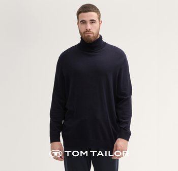 Ciemnogranatowy sweter z golfem z miękkiej, teksturowanej tkaniny, z długimi rękawami i luźnym krojem, prezentowany na modelce na jasnym tle.